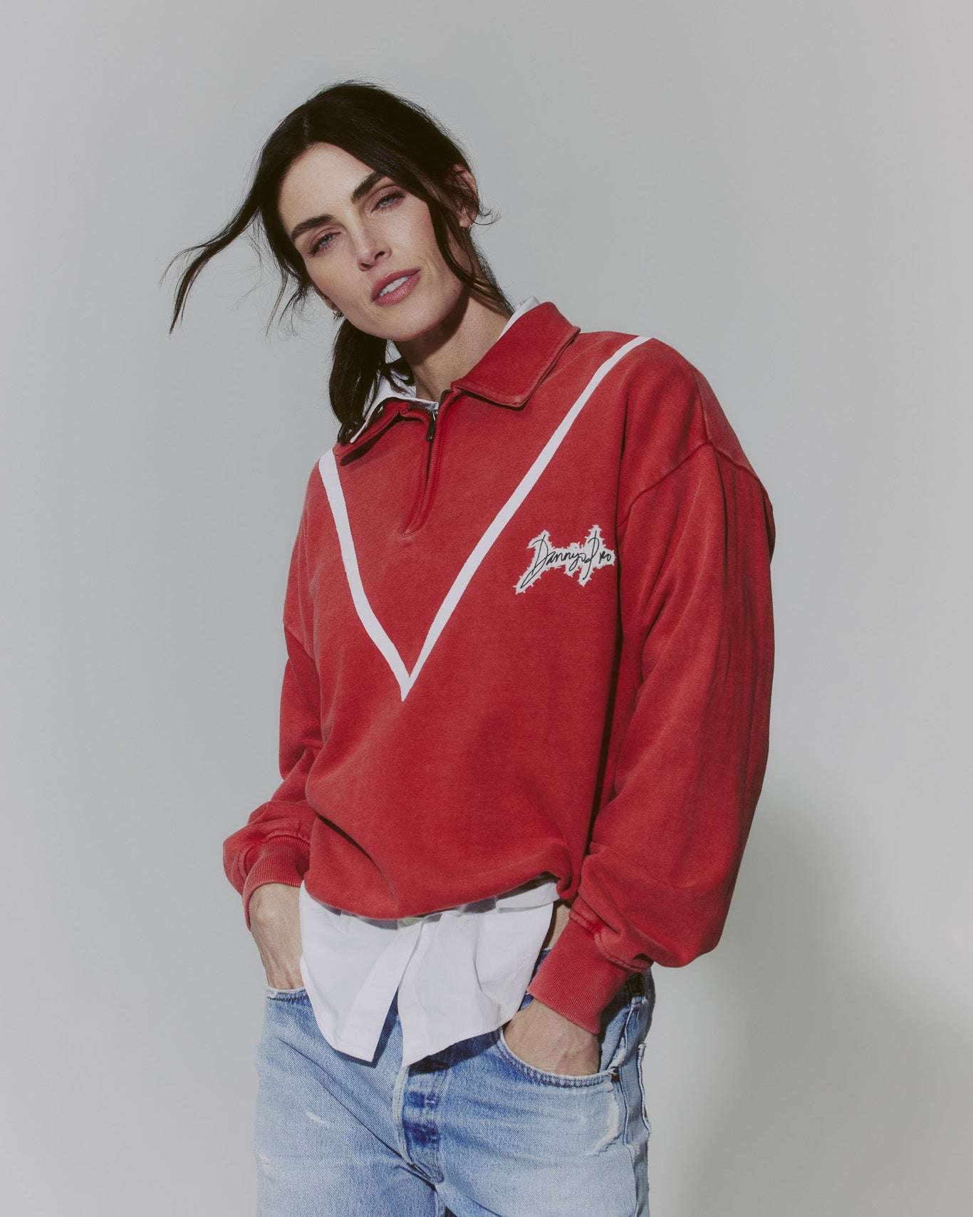 Model wearing red DJP Signature Half Zip oversized hand-painted pullover with collar and white striped detail