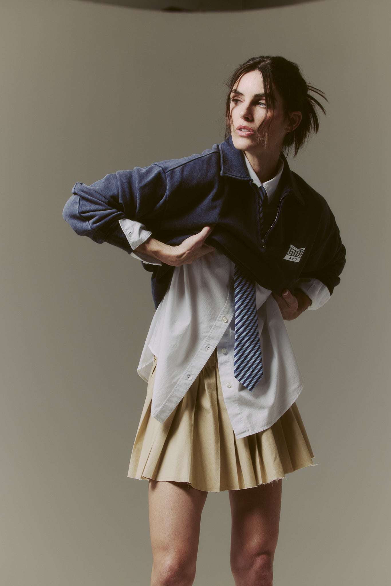 The Classic Quarter Zip navy unisex soft pullover on female model wearing a white shirt and beige skirt