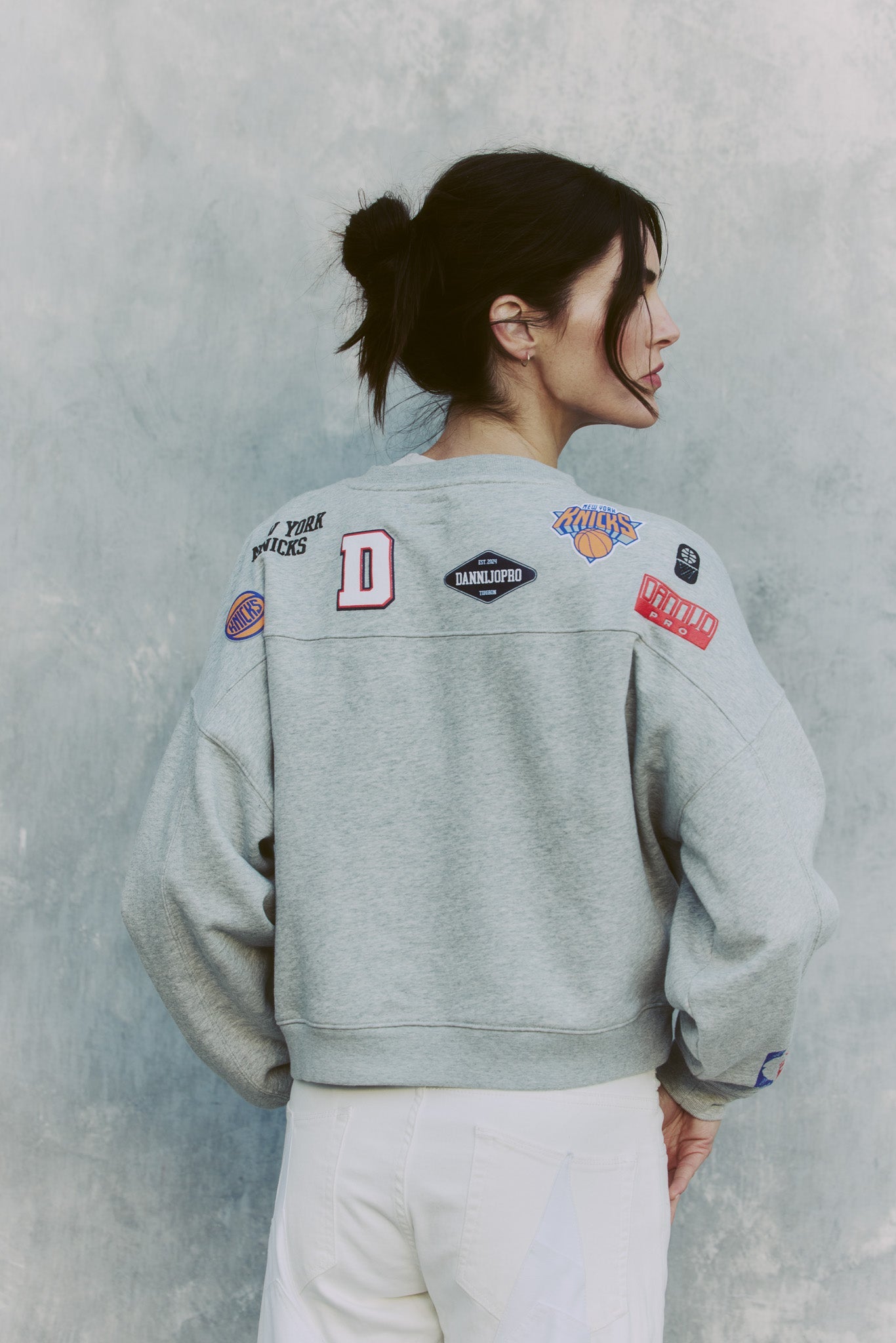 The Collegiate Crewneck Knicks gray sweatshirt with NBA team logos and patches