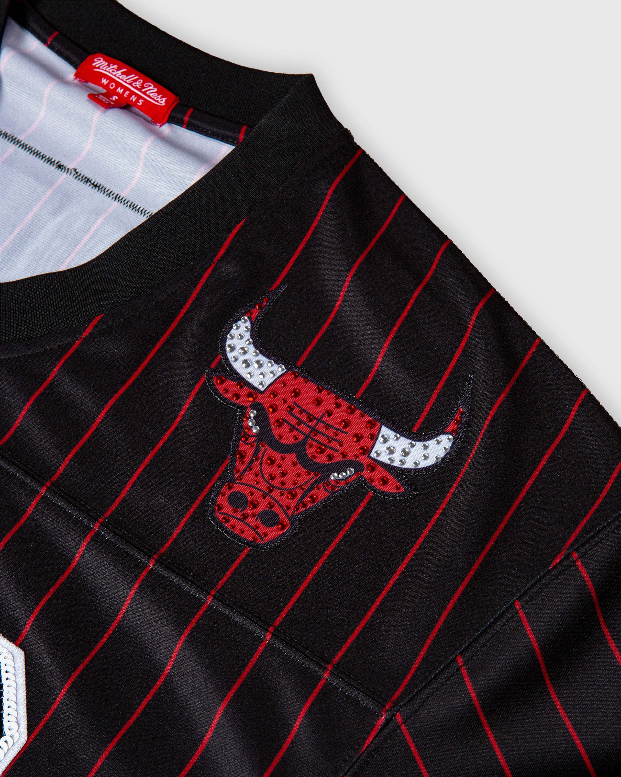 Close-up of black Scottie Pippen Chicago Bulls jersey with red pinstripes and rhinestone-studded Bulls logo