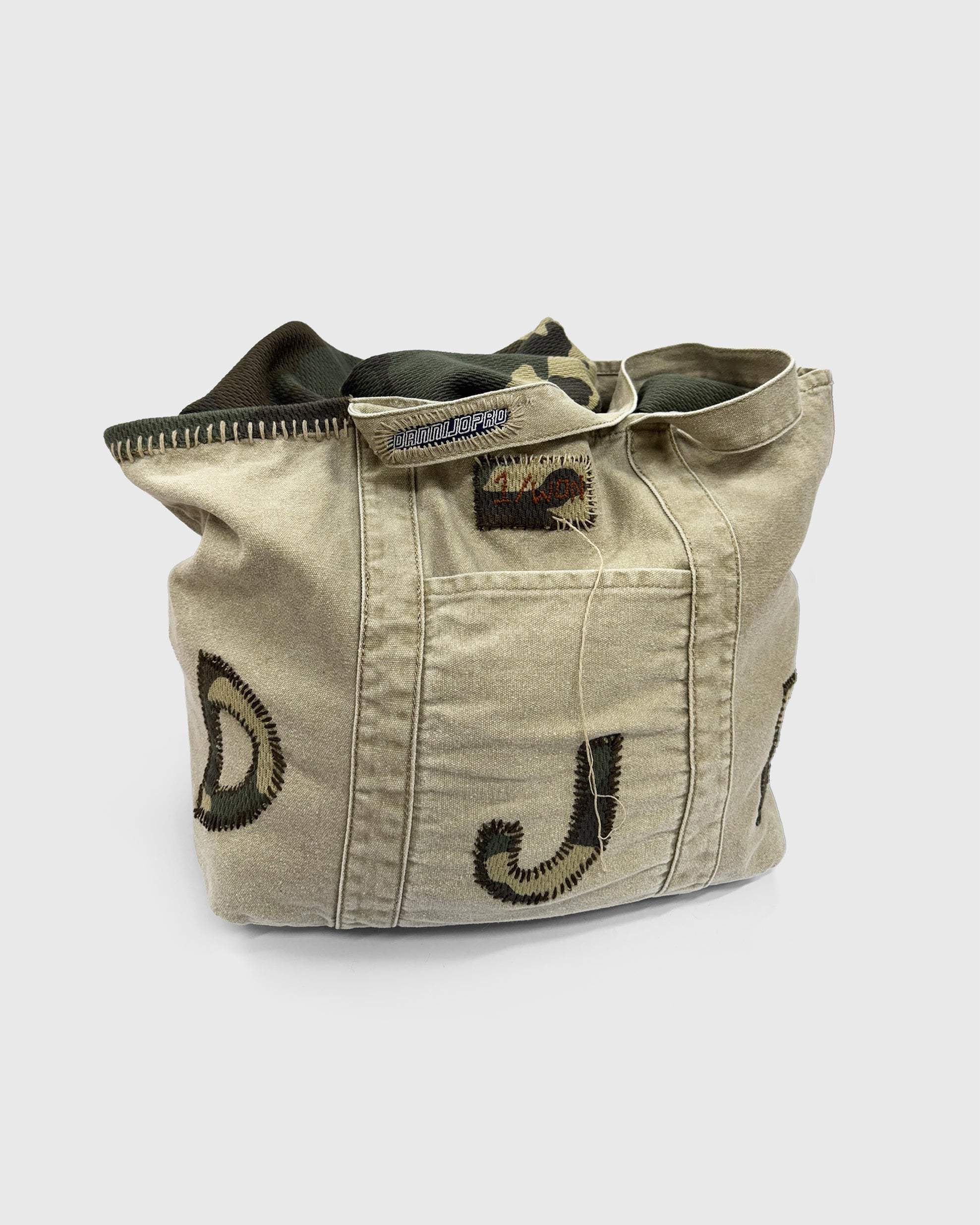 Hand-stitched camo initial bag with distressed finish, ideal for market, beach, gym, or diaper use