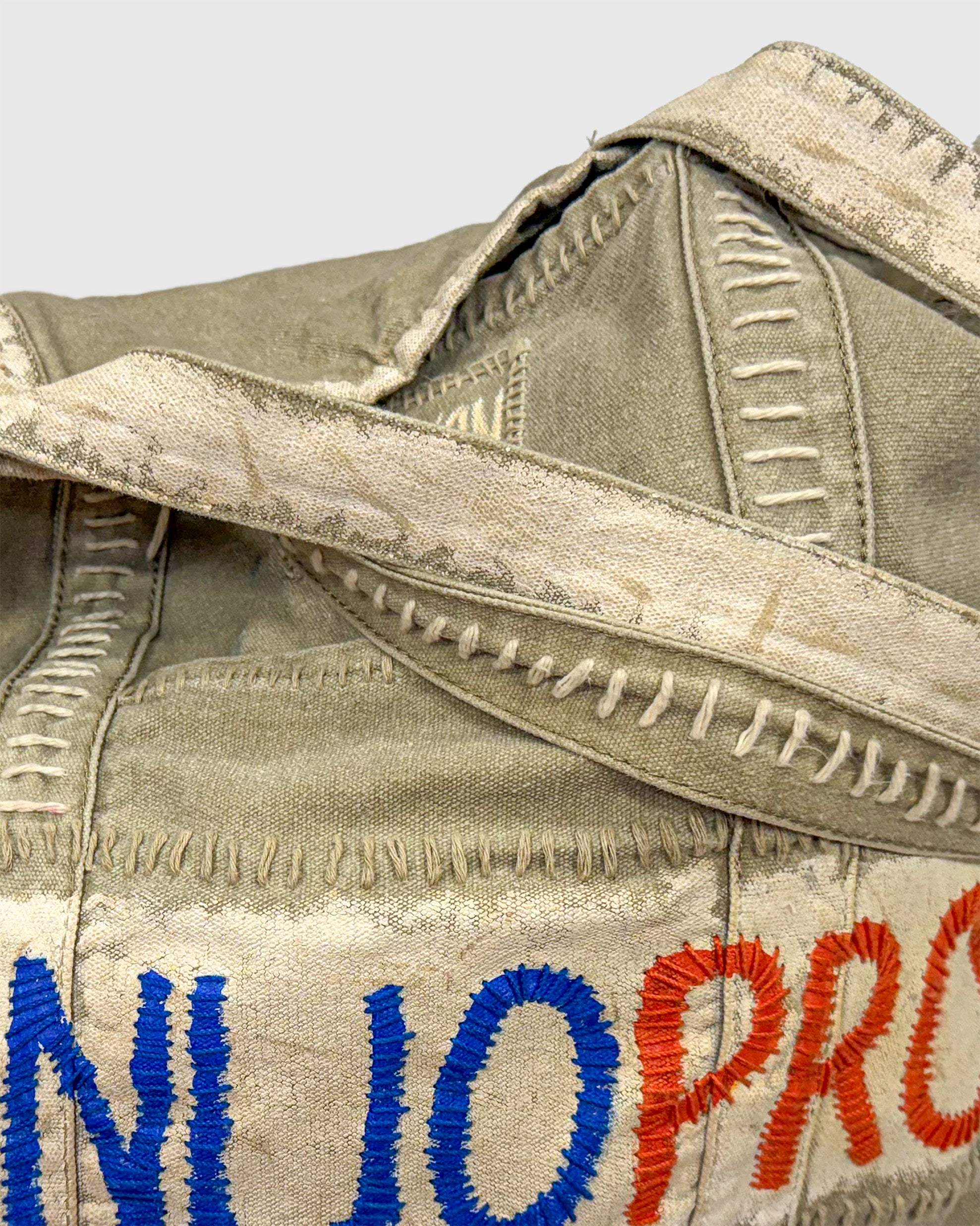 Close-up of hand-stitched WON DANNIJOPRO Bag made with distressed fabric and detailed embroidery