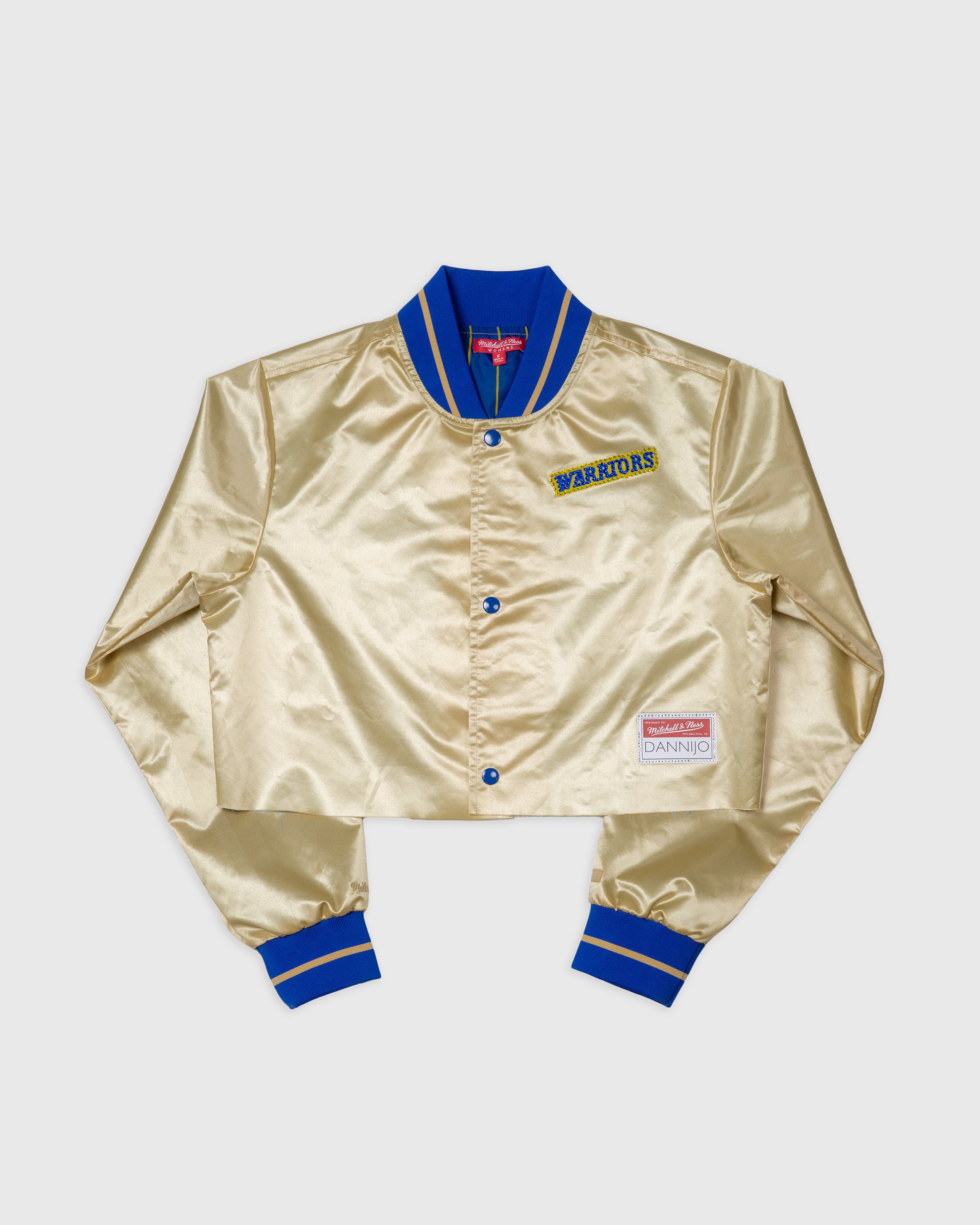 a cropped satin jacket in gold with blue trim, featuring the Golden State Warriors emblem and text details